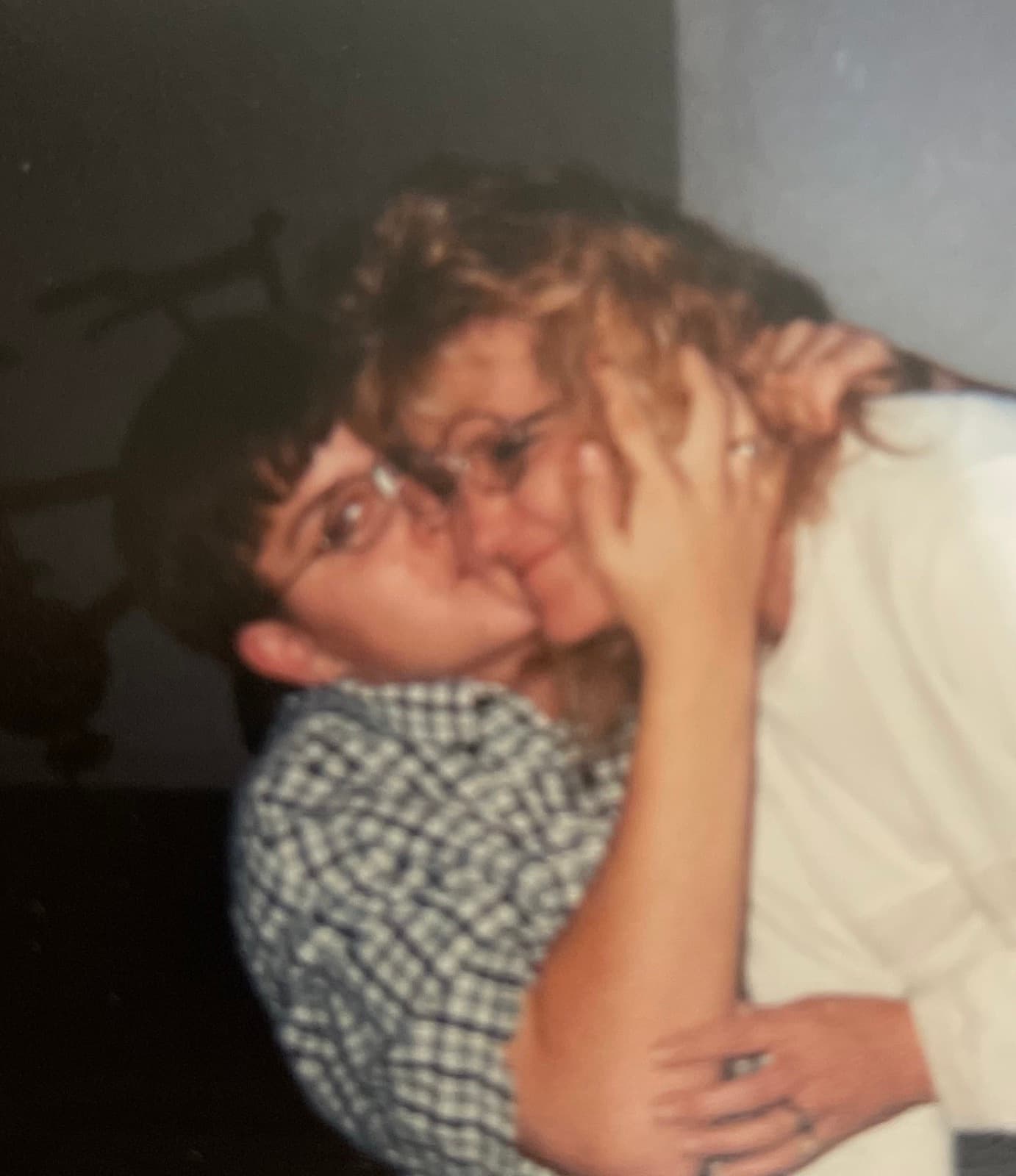 Curtis as a teenager, in glasses, kissing his mother on the cheek